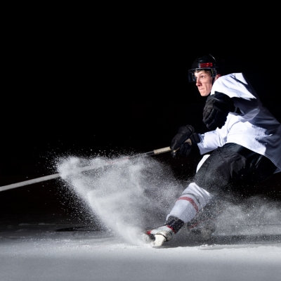 Ice hockey player in action kicking with stick